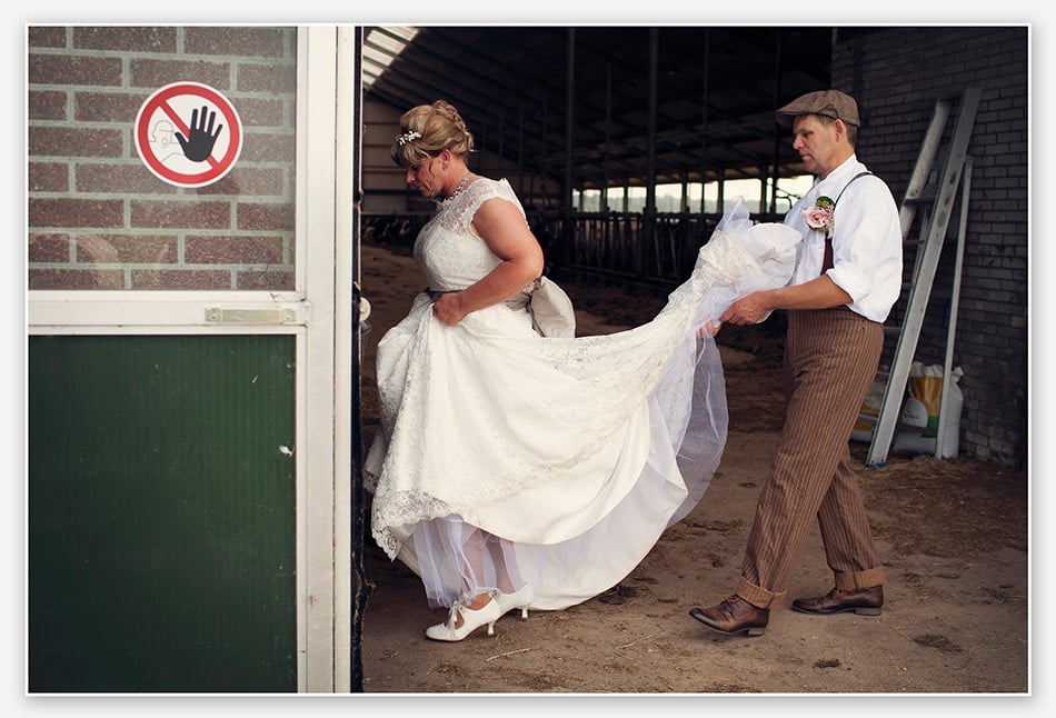 Bruidegom geleid zijn bruid door de koeienstal
