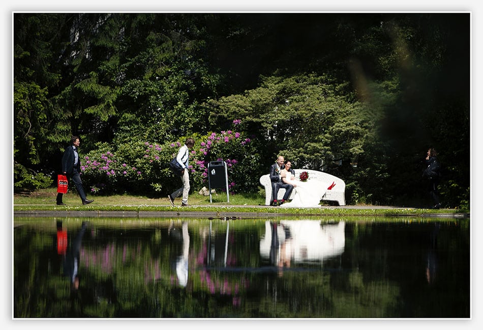 Bruidsfotografie - Bruidspaar op bankje met waterspiegeling
