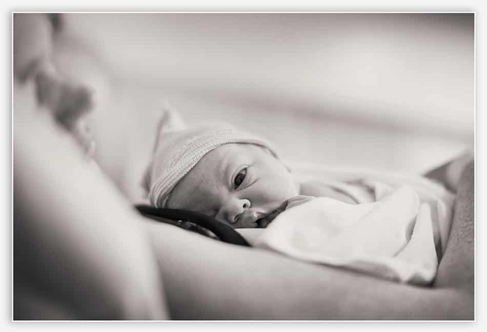 Pasgeboren baby kijkt in de camera