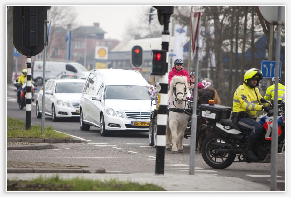 De rouwauto sluit aan bij de rouwstoet