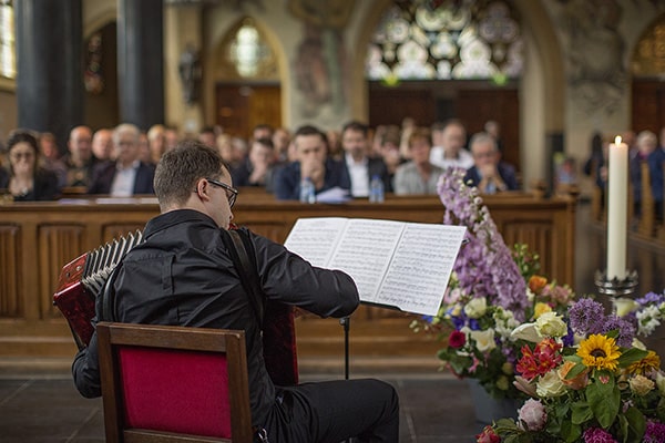 Soulmates Images_Afscheidsfotografie_06_zoon speelt akkordeon op uitvaart