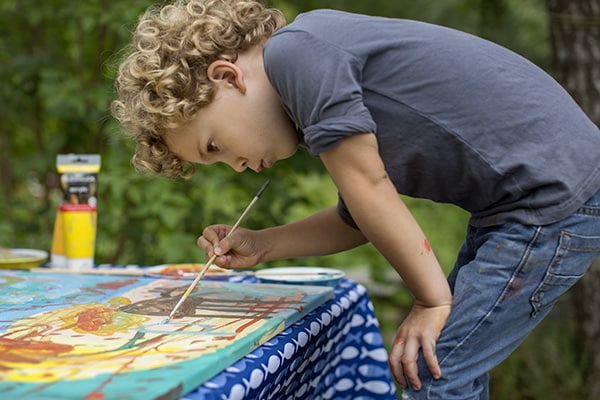 Soulmates Images_Familie-uitjes_04_jongen beschildert groot canvasdoek