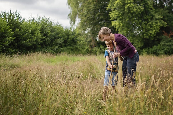 Soulmates Images_Familie-uitjes_05_moeder en zoon zoeken beestjes in de wei