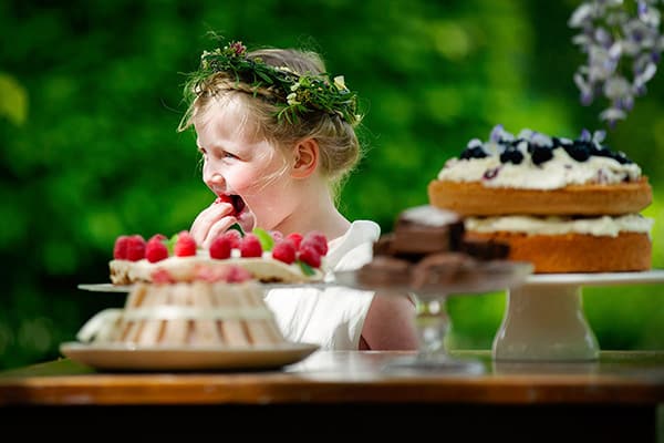 Trouwfotografie_Soulmates Images_09_bruidsmeisje snoept van de bruidstaart