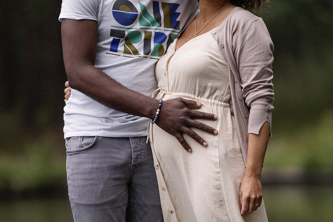 Vader legt hand op zwangere buik