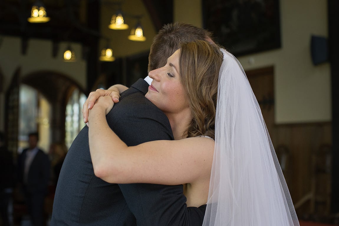 Bruid geeft haar broer een knuffel na ceremonie in Vught