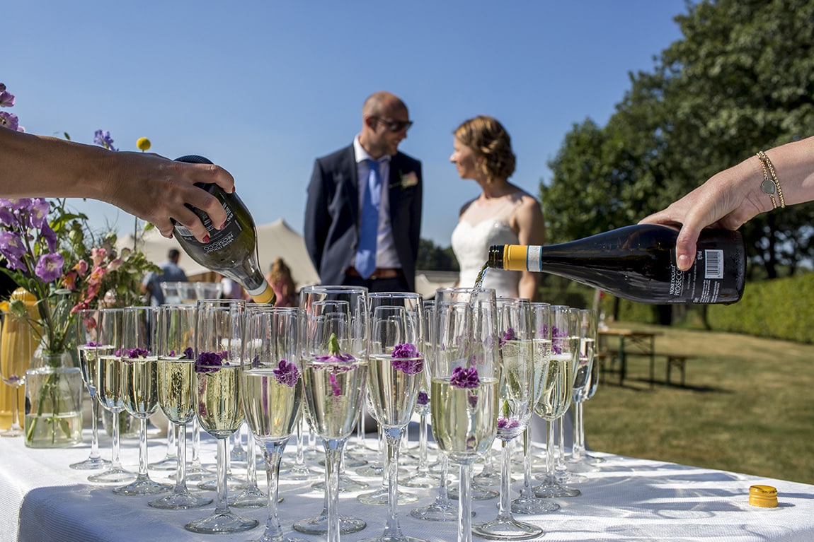 Champagneglazen worden gevuld voor bruidspaar in Vinkel