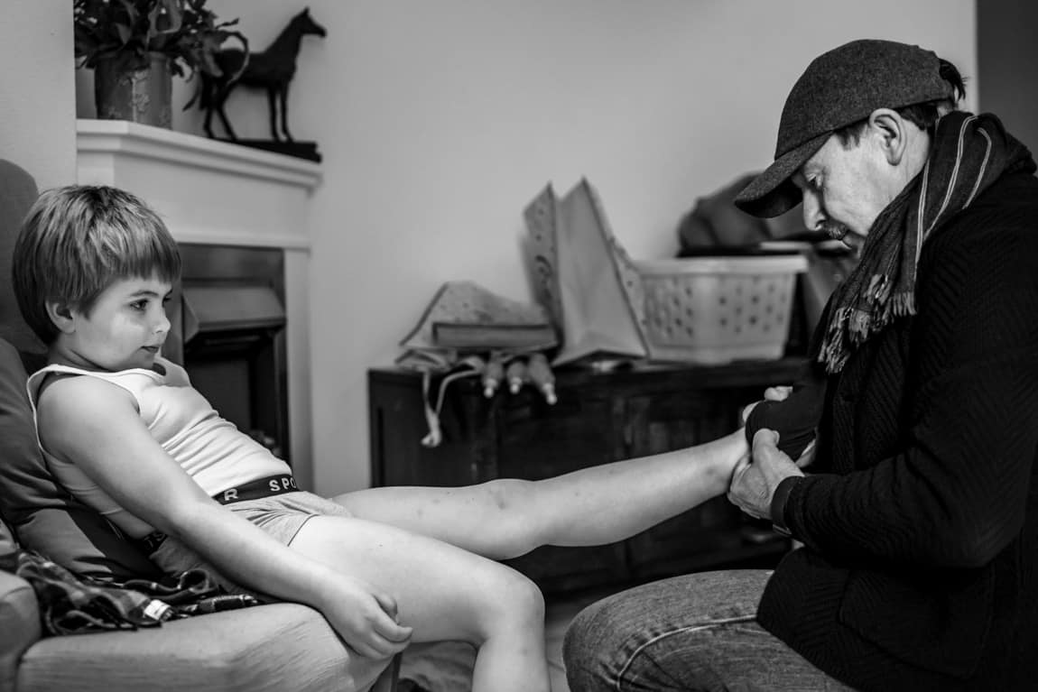 Opa helpt bruidsjonker met aankleden