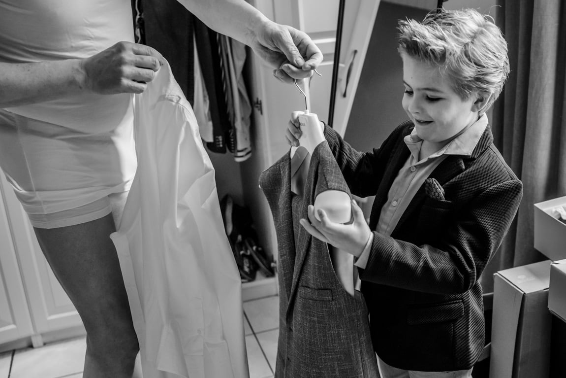 Bruidsjonker helpt bruidegom met aankleden