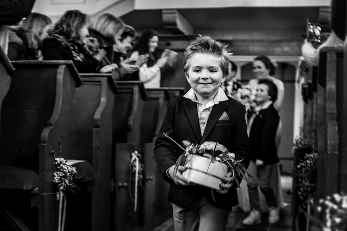 Bruidsjonker loopt kerk in met ringendoos