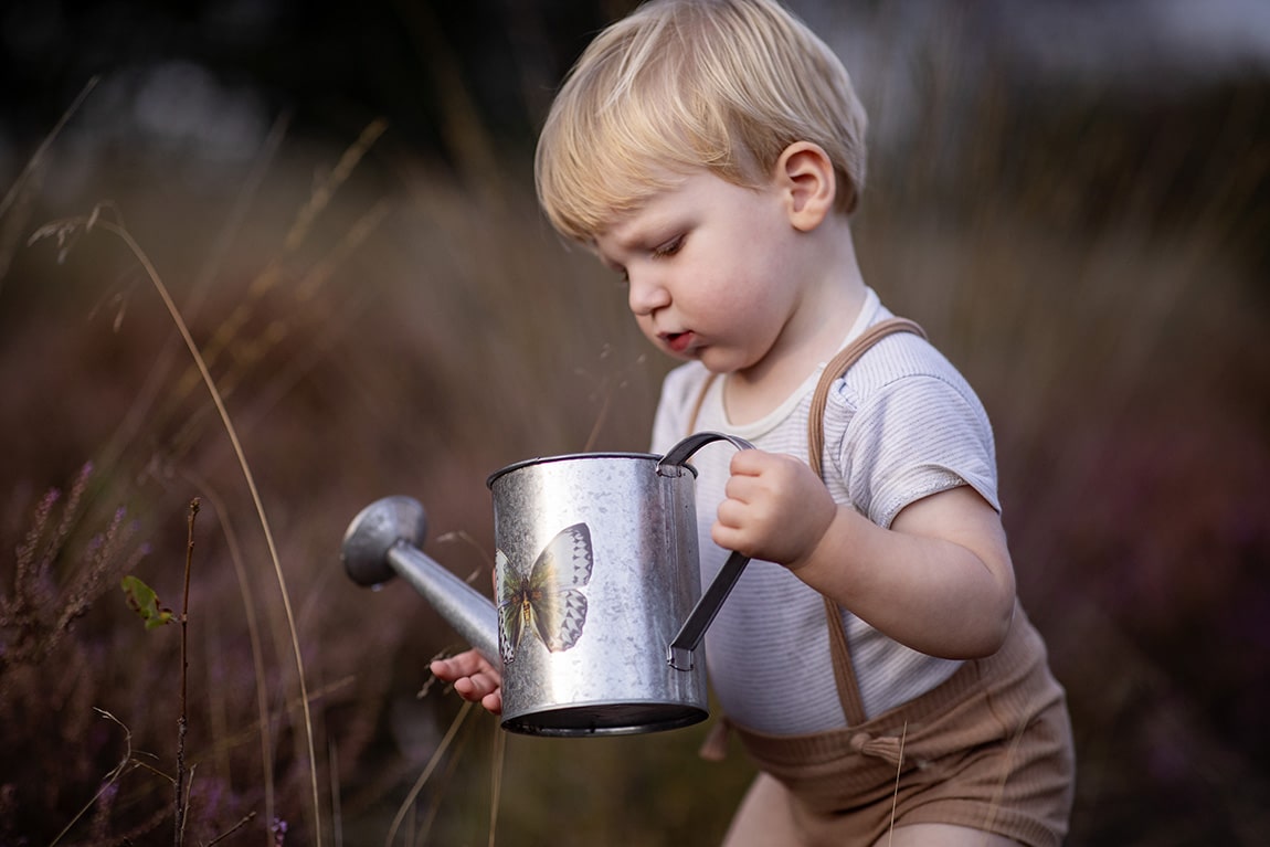 Kind met gieter op de heide