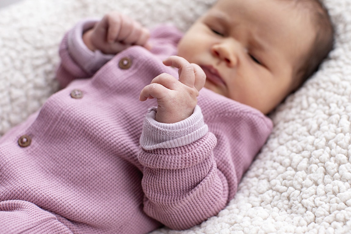 Newborn baby bekijkt haar eigen handje 