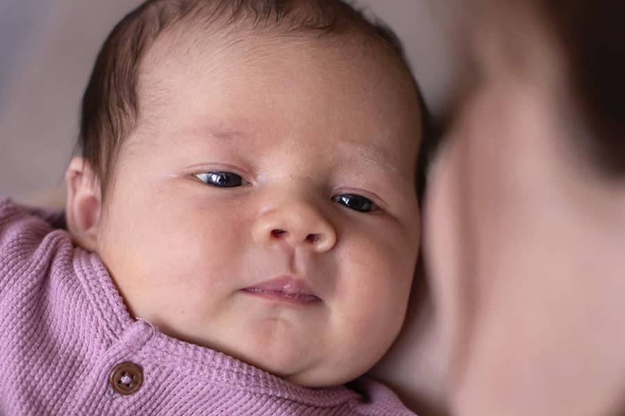 Baby kijkt moeder aan tijdens newbornreportage