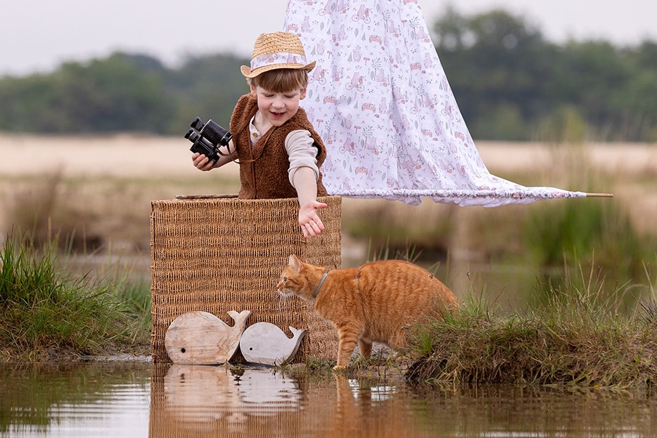 Magische kinderfotografie met zeilboot en kat