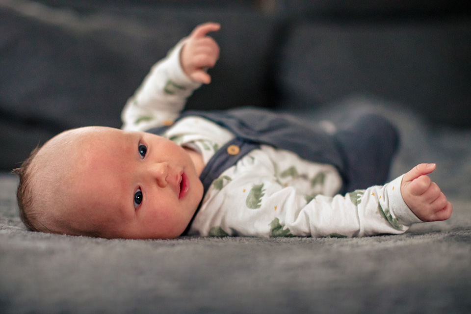 Baby met prachtige ogen ligt naar zijn moeder te kijken