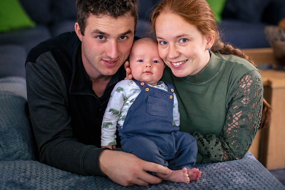 Familiegeluk met ouders die hun nieuwgeboren baby vasthouden.