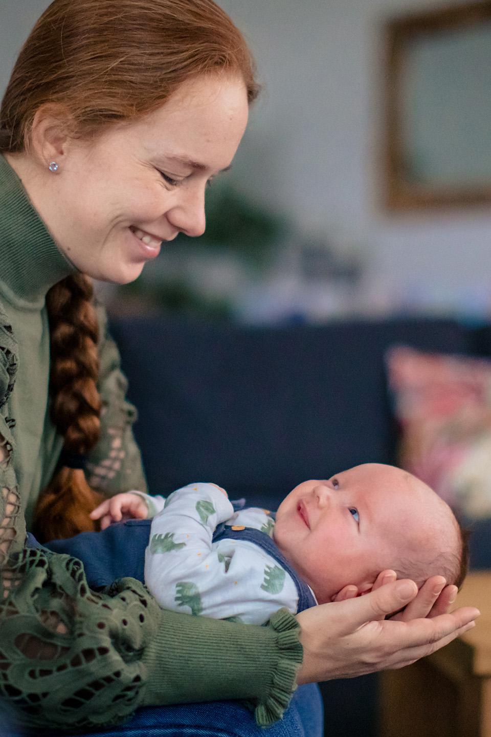 Baby ligt in de armen van zijn moeder heel lief naar haar te glimlachen