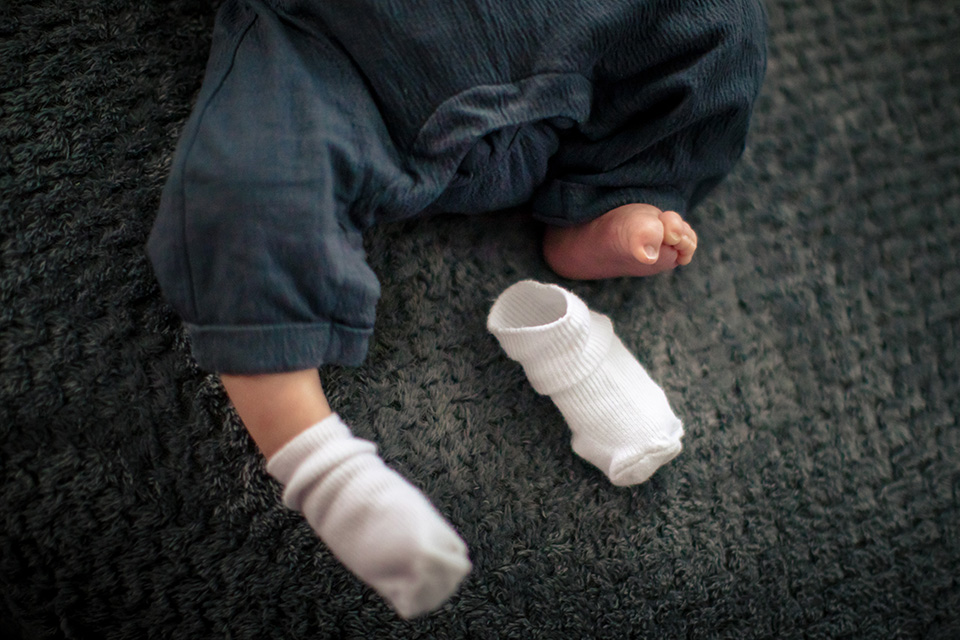 Babyvoetjes waarbij één sok is uitgeschopt