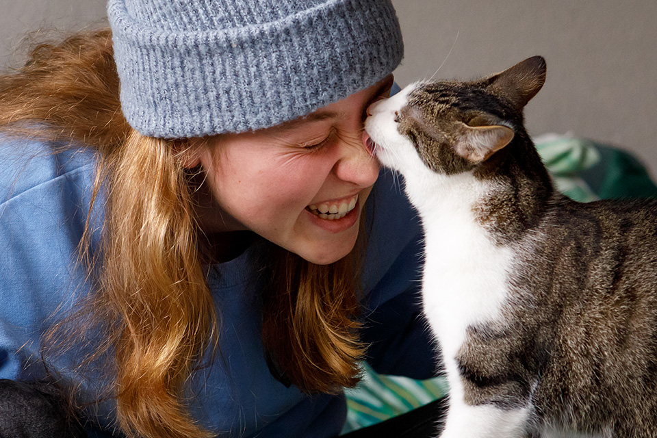 Kat likt gezicht af van haar lachende vrouwtje